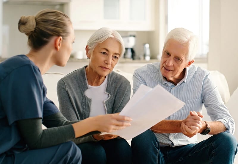 Senior couple reviewing Medicare supplement insurance documents with a licensed agent